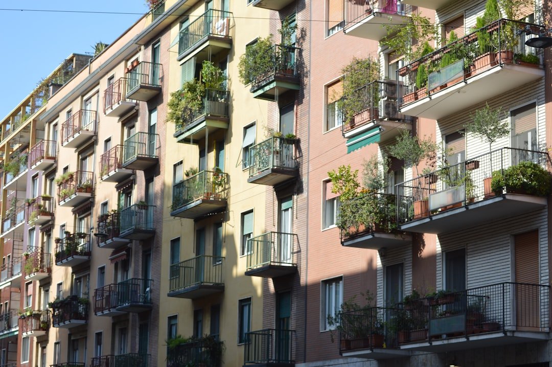 A row of apartment buildings with balconies and plants on the balconies