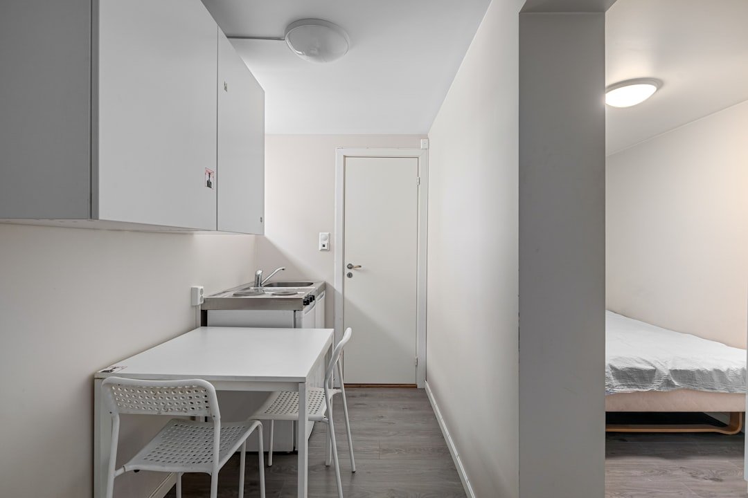 A room with a bed and a table and chairs