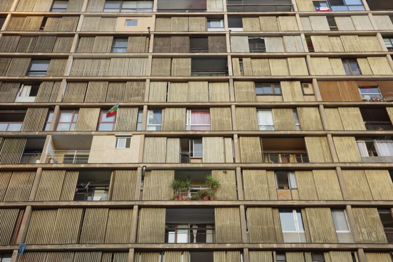 A brutalist building facade with many windows and balconies.