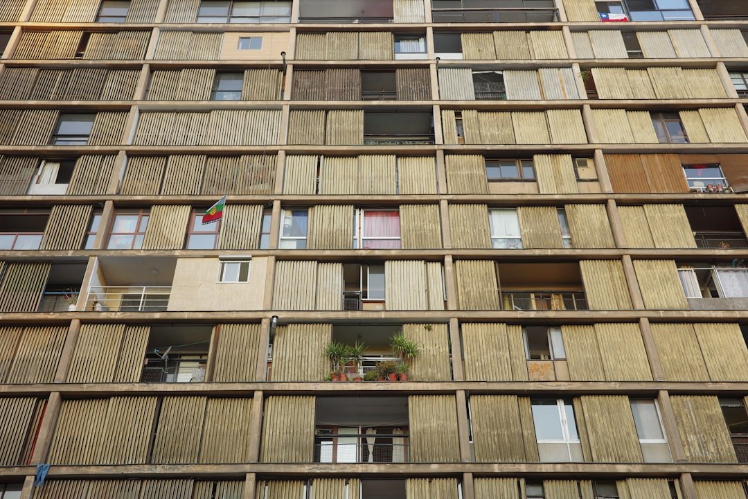 A brutalist building facade with many windows and balconies.
