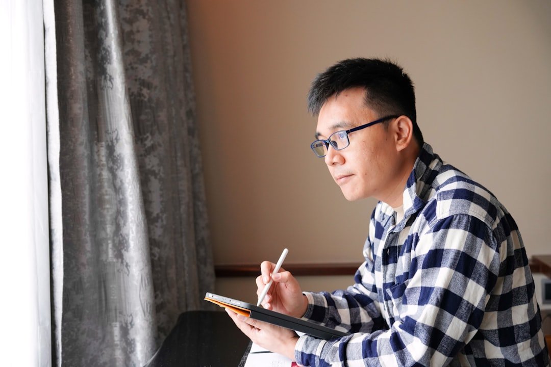 A man sitting at a desk writing on a piece of paper