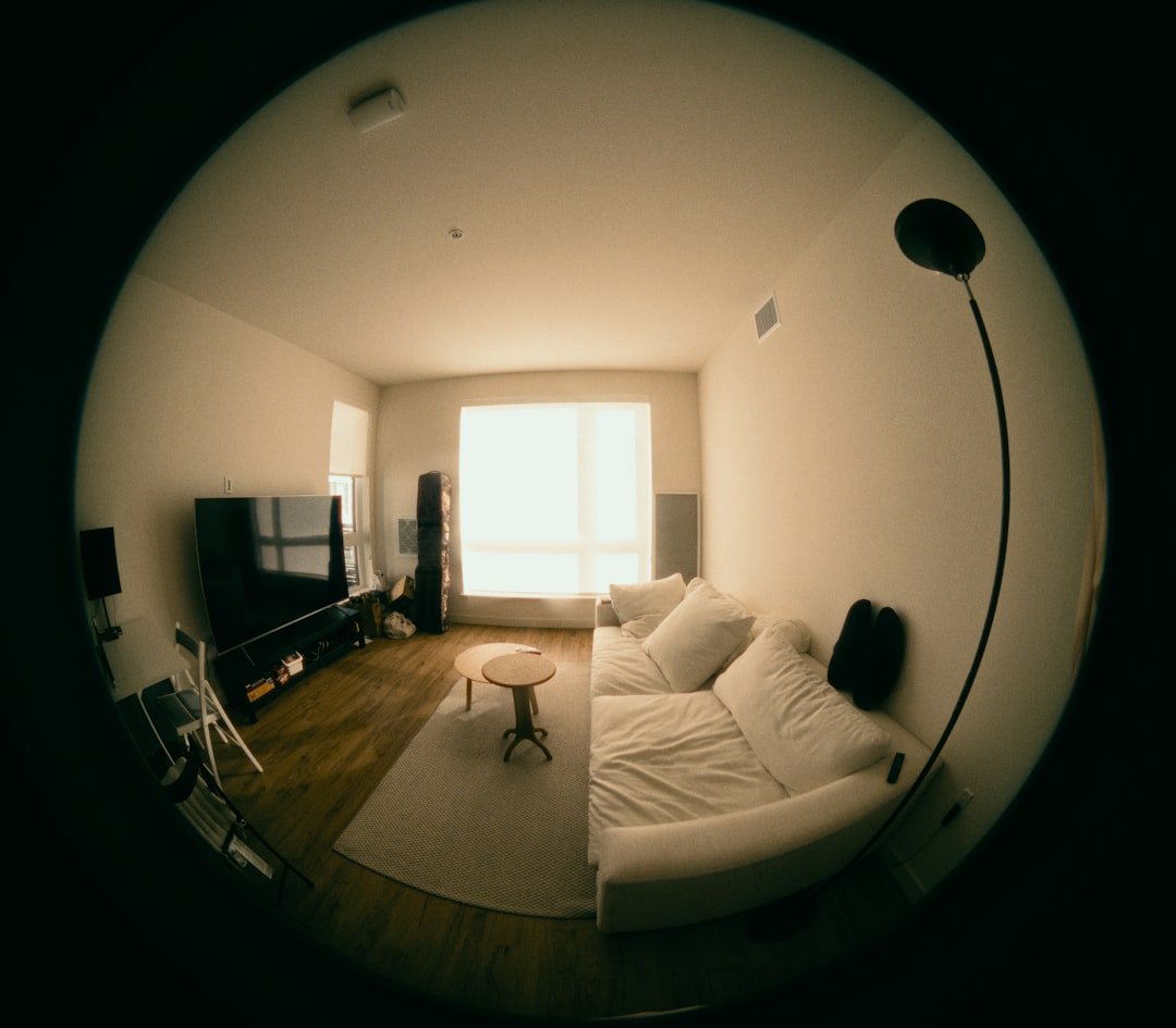 Modern living room with white sofa and large window.